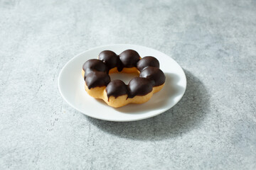 A view of a chocolate mochi donut, on a plate.