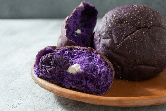 A view of some ube pandesal rolls, filled with cream cheese.