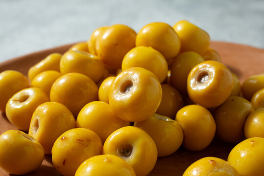 A closeup view of a pile of nance, on a plate.