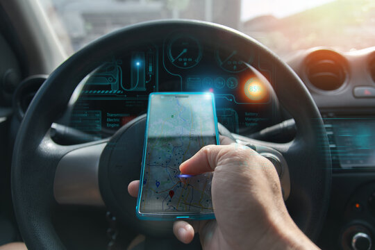 Futuristic view of a person using augmented reality navigation through a transparent smartphone interface inside an electric vehicle, displaying real-time EV dashboard data and map location.