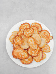 Small pancakes with funny faces forming a delicious breakfast on a white plate