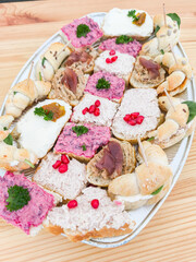 Catering platter displaying colorful assortment of canapes on wooden table