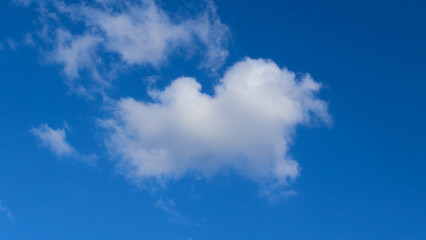 Sky's Embrace: A serene capture of a solitary cloud, illuminated against a vast, clear, blue sky, showcasing the ethereal beauty of nature.