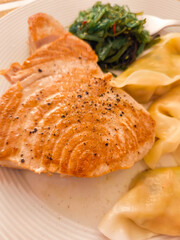 Seared tuna steak with seaweed salad and dumplings, culinary fusion delight