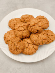 Freshly baked oat cookies resting on a white plate