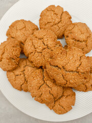 Freshly baked oat oat cookies resting on white plate