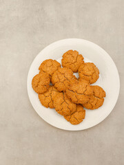 Freshly baked peanut butter oat cookies resting on white plate