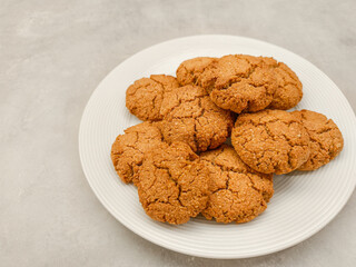 Freshly baked oat cookies resting on a white plate