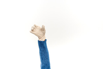 Isolated arm in a blue sweater wearing a disposable glove reaching or holding something on a white...