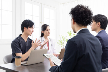 病院で打合せをする医療従事者
