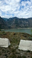 Crystal-clear mountain lake nestled among emerald green slopes and rugged peaks. Peaceful wilderness reflecting in still waters under summer skies — perfect nature escape.

