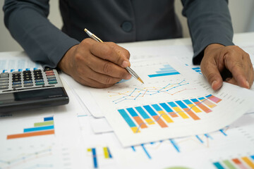 Asian business woman working with financial graph.