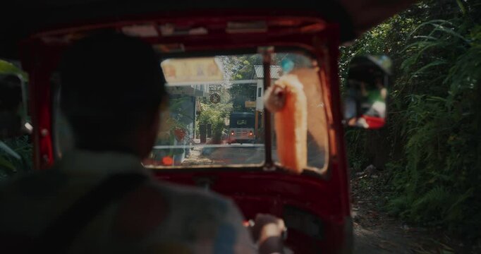 Tuk tuk driver carries a passenger along jungle road. . Slow motion. POV View sri lanka village country road