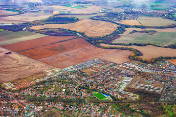 Aerial autumn fields and city of Slovakia. Top view slovak town with green sports fileld and farms