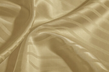 Smooth, elegant golden silk fabric with a flowing, shiny texture creates a luxurious backdrop