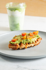 A view of an avocado toast croffle and matcha latte.