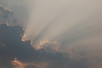 Heavenly Rays Piercing Through: Majestic sunbeams burst through a break in the clouds, casting an...
