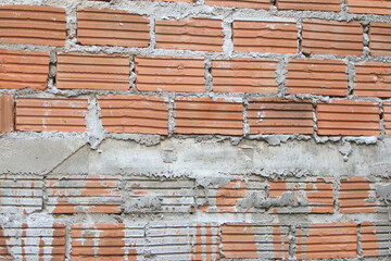 Brick Wall Texture: A detailed, close-up shot reveals the weathered texture of a red brick wall, each brick meticulously laid and bound together with cement.