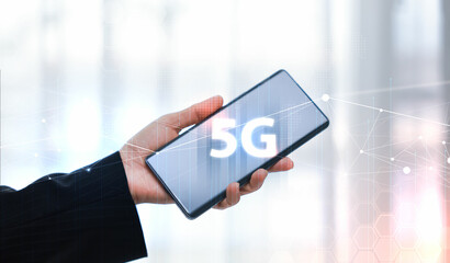 Hand holding smartphone with 5G icon and global network interface, representing high-speed wireless technology, digital connectivity, IoT, and future communication concept. communication network.