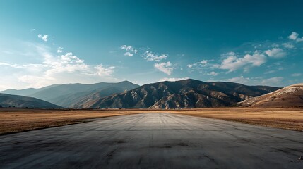 A wide-angle ground with a clear sky and mountainous background for vehicles or products placement. Copy space image. Place for adding text or design .