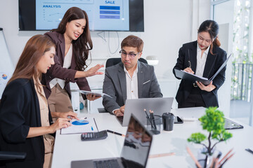 Group of business people are standing in a meeting presenting their work at the office.
