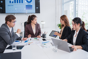 Group of business people are standing in a meeting presenting their work at the office.