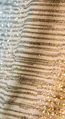 Elegant fabric detail showcases a textured, patterned surface with subtle shimmering stripes, suitable for various design projects.