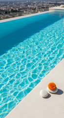 Serene rooftop pool sparkles in sunlight with orange flower and white stones, creating a relaxing vacation vibe.