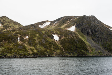 Rocky Fjordside Mountain with Snow