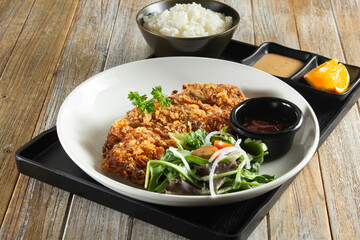 A view of a bento box, featuring chicken katsu.