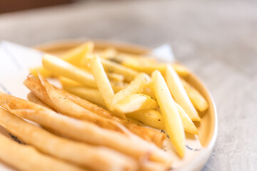 Pile of French fries on dish. Selective focus