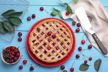 Tasty cherry pie and berries on light blue wooden table, flat lay