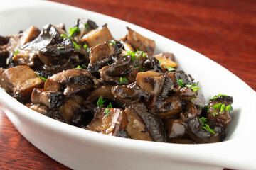 A closeup view of a bowl of sauteed mushrooms.