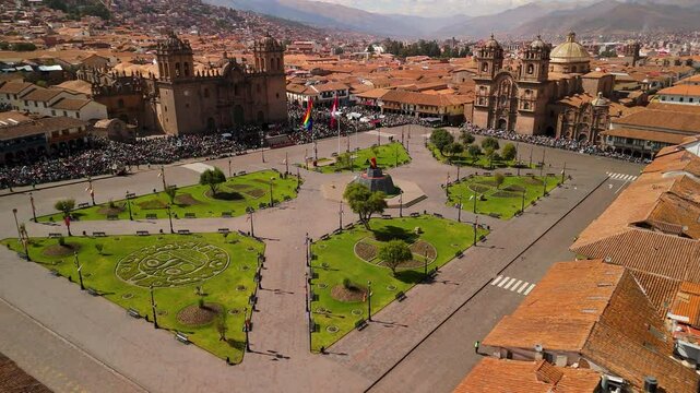 A stunning aerial flyover with a right pan reveals the immense scale of the Inti Raymi festival, showcasing the massive crowd filling the historic Plaza de Armas in Cusco, Peru.