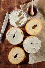 A top down view of gluten-free bagels smeared with dairy-free cream cheese.