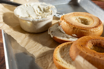 A closeup view of gluten-free bagels smeared with dairy-free cream cheese.