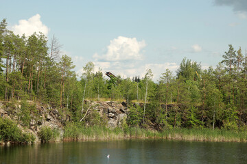 Beautiful quarry lake among forest and rocks