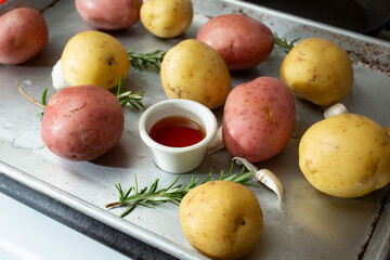 A view of ingredients on a tray, in preparation of honey roasted potatoes.