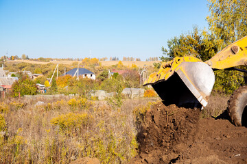 Yellow bulldozer at a construction site. Big wheel excavator leveling and clearing the land plot...