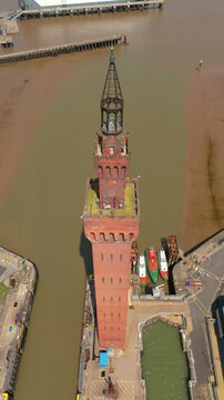 Vertical aerial drone shot of Clock tower and fishing port area ferry terminal Humber estuary Grimsby England UK