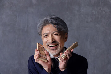 札束を持つ笑顔のシニアビジネスマン