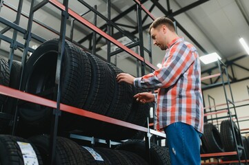 Tire repair service. A man chooses new tires for his car.
