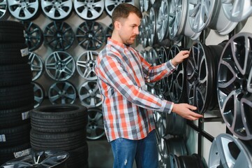 The buyer chooses new alloy wheels for his car