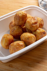A view of polenta roasted potatoes in a white plastic container.
