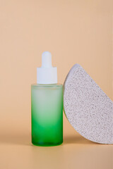 Green glass cosmetic bottle, Skin care or sunscreen cosmetic with stylish props on cream background.