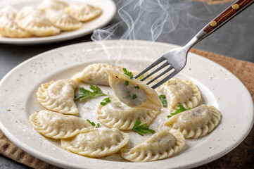 shows a plate of dumplings garnished with parsley, with a fork lifting one up. Smoke is rising from the dumplings, indicating they are hot.