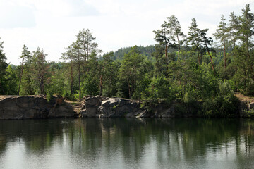 Beautiful quarry lake among forest and rocks