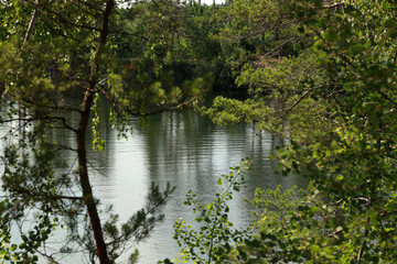 Beautiful quarry lake among forest and rocks