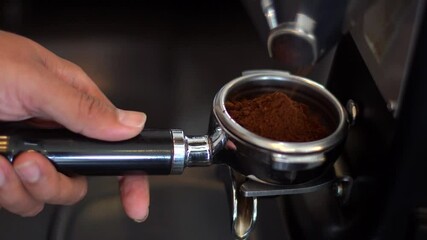 Barista fill the portafilter with coffee grounds to make espresso - Powered by Adobe