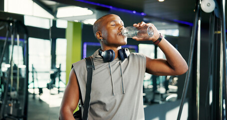 Thirsty, man and drinking water in gym, break and nutrition for healthy body, exercise and...